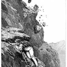 A mountaineer climbing an uneven rock face tries to shield himself from falling rocks