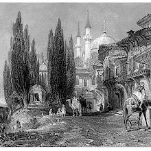 A street flanked by houses with corbelled windows leads to Emir Sultan Mosque